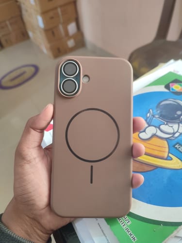 Customer holding the brown Anti Dust MagSafe Silicone Case, showing the MagSafe symbol on the back.