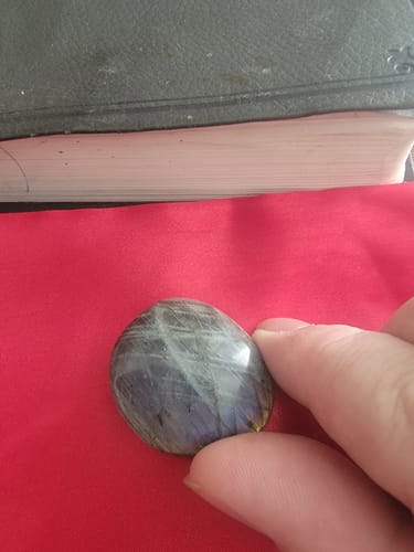 A reviewer holding a polished, iridescent crystal from the VIP Crystal Club in their hand.