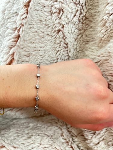 Reviewer's wrist wearing the Cube Link Bracelet, showing its simple design with small cube charms.