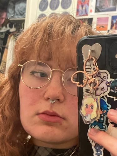 Customer's close-up selfie showing the Butterfly Septum worn in their piercing.