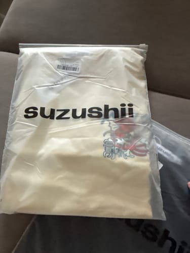 Customer's Koi King T-Shirt shown inside its clear branded packaging.