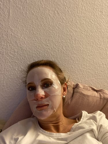 Eine Rezensentin entspannt sich mit der aufgetragenen Kollagen Boosting Maske.