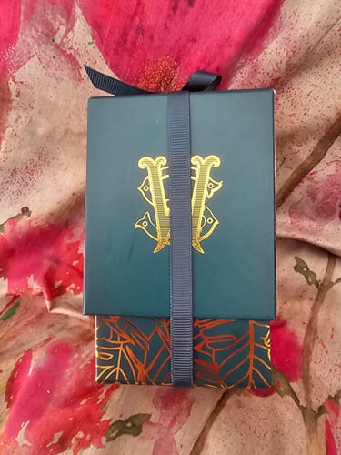 Customer's Surfari fragrance box, showing a teal lid with a gold monogram over a patterned base.