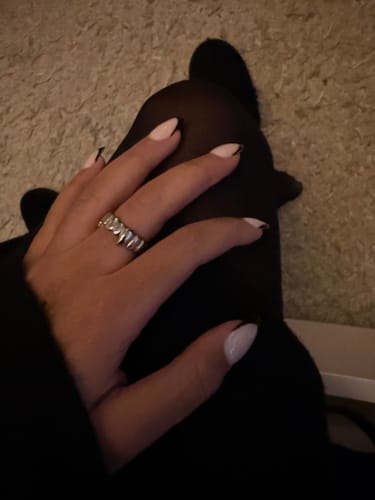 A customer's hand with a fresh manicure wearing the chunky GRILL RING on their finger.
