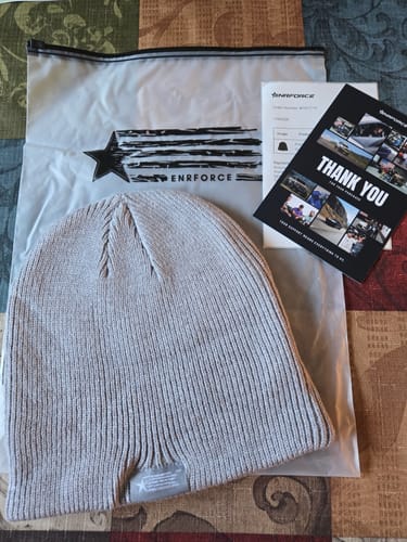 Reviewer's grey ribbed Premium Beanie laid flat next to its product packaging.