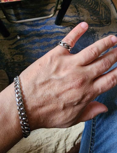 Primer plano de la mano de un cliente usando la Pulsera Cuban 8mm plateada y un anillo a juego.