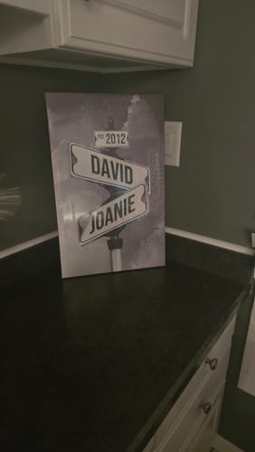 Customer's COUPLES DATE OF LOVE canvas with names 'David' and 'Joanie' on street signs, resting on a kitchen counter.