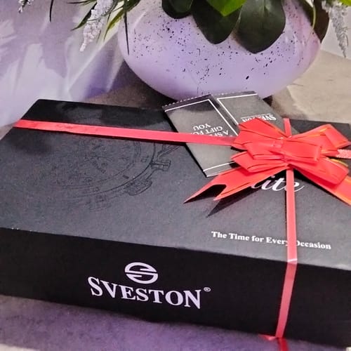 Reviewer's photo of the gift wrapping on a black Sveston brand box, tied with a simple red ribbon and bow.