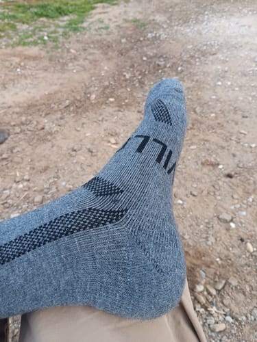 Customer's foot wearing the grey and black Men's Alpaca Sock outdoors.