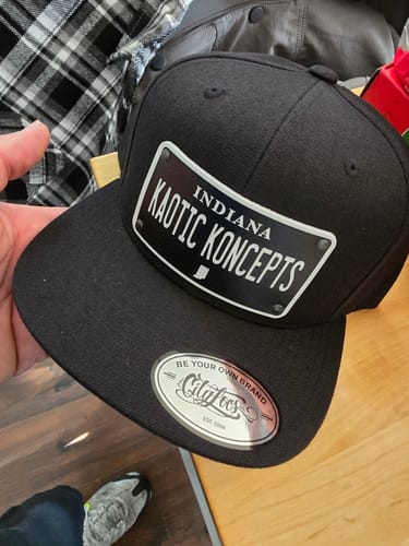 Customer holding their black Indiana Blackout Plate Hat with a flat bill and a 'KAOTIC KONCEPTS' custom patch.