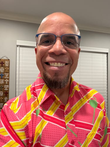Reviewer smiling in a close-up, wearing the bright pink and yellow "Hoverboard Havoc" shirt.