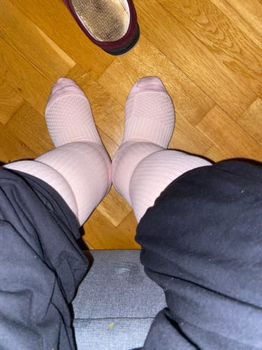 Recensent som visar de ljusrosa Diasocks Stödstrumporna på sina fötter och ben.