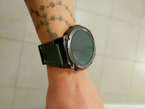 Reviewer wearing a durable work watch with a green band on their wrist.