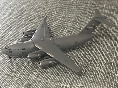 Customer's model of a gray U.S. Air Force C-17 Globemaster III airplane on a patterned surface.