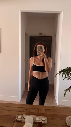 Reviewer in a mirror selfie showing the flattering fit of the black V Legging's v-waistband.