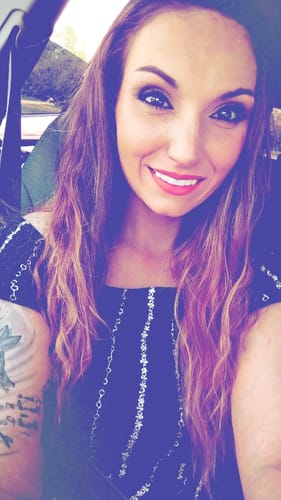 A customer smiles confidently in a selfie, showing off her bright white Spare Veneers.