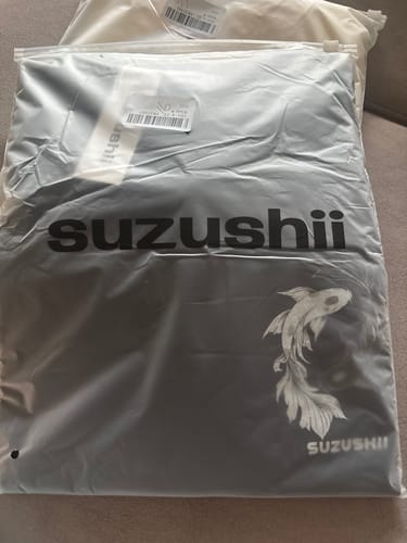 Customer's black Ying Yang Koi T-Shirt with a white koi graphic, seen inside its clear brand packaging.
