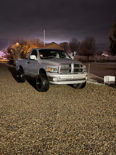 Customer's silver Dodge Ram with a wider stance after installing 1.5 Inch Hubcentric Wheel Spacers, viewed at night.