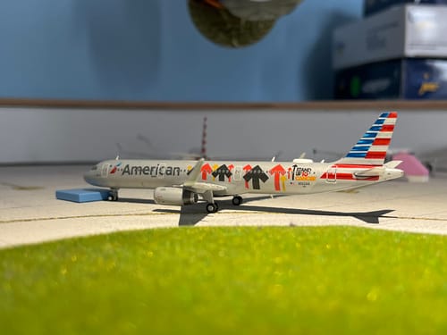 Customer's American A321 'Stand Up To Cancer' model airplane displayed on a miniature airport tarmac as part of a collection.