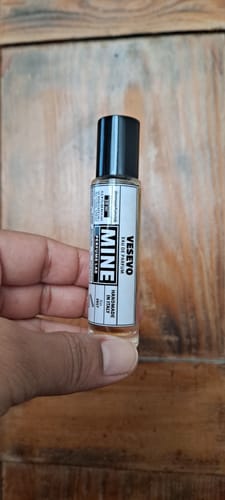 Un recensore tiene in mano la piccola boccetta di vetro dell'eau de parfum Vesevo.