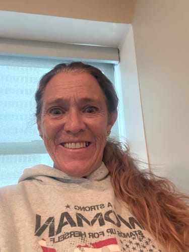 Reviewer smiling, showing moisturized skin after using the Grass Fed Tallow & Honey Balm.