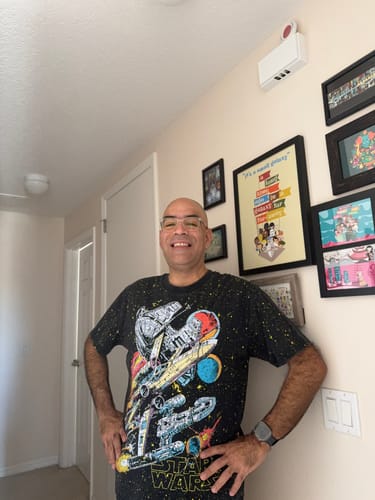 Customer smiling while wearing the Star Wars™ 'Built to Rebel' vintage tee in a hallway.