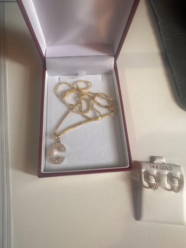Customer's 14K initial 'C' CZ pendant and chain in a jewelry box next to a pair of matching hoop earrings.