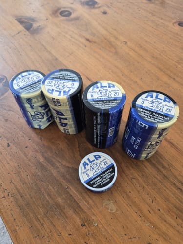 Customer's stock of Chilled Mint Nicotine Pouches, showing four rolls and one can on a wooden table.