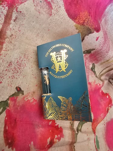 Customer's sample vial of Tabac Soleil perfume in its decorative teal and gold card holder.