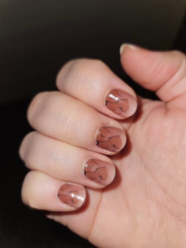 Kundenrezension: Eine Hand zeigt die aufgetragenen „Neutral Love“ UV-Gelfolien mit einem Design aus braunen Herzen.