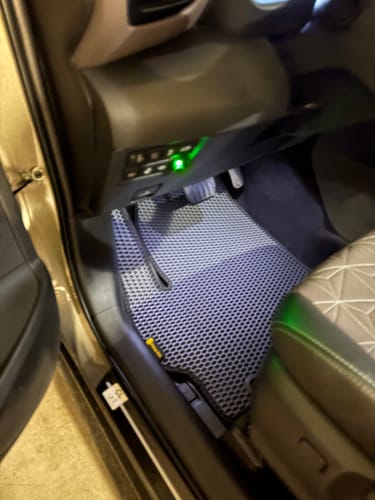 Niebieski dywanik samochodowy klienta o fakturze plastra miodu, dopasowany po stronie kierowcy.