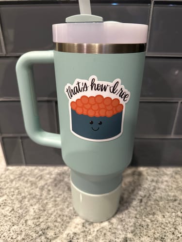 Customer's "That's how I roe Sticker" applied to a light turquoise tumbler cup with a handle.