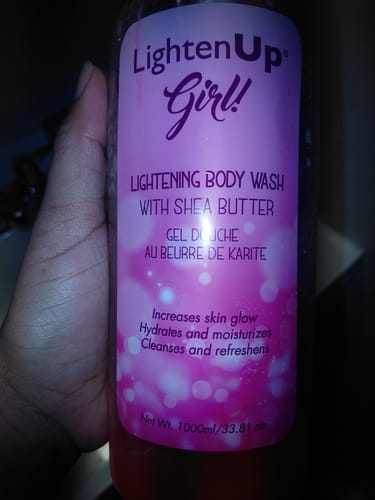 Customer holding a large bottle of LightenUp Girl! Lightening Body Wash, showing the pink label.