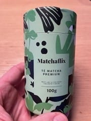 Reseñador sosteniendo en la mano el envase cilíndrico del Té Matcha Premium.