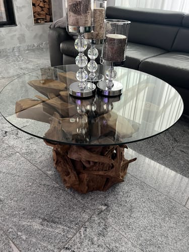 Kundenfoto des IKAL Wurzelholz-Couchtisches mit Glasplatte in einem Wohnzimmer.