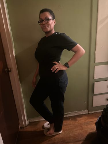 Customer posing indoors showing the front and fit of the black American Values Tee.