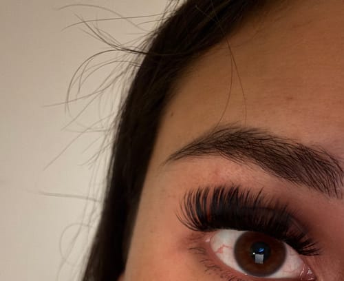 Nahaufnahme des Auges einer Rezensentin mit den langen, geschwungenen First Date Wimpern.