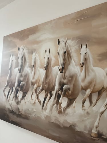 Customer's 'Seven White Running Horses' canvas with neutral tones, viewed from an angle while hanging on a wall.