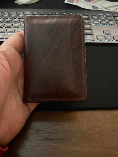 Customer holding their dark brown Diablo Slimline Card Holder, showing the leather's developing patina.