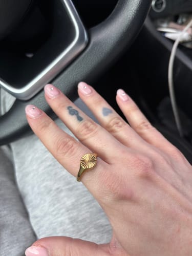 A reviewer's hand showing the detailed gold Ellie® Sunburst Rising Ring.