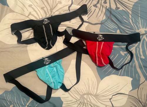 Reviewer's Nylon Mesh Jockstrap 3-pack in black, light blue, and red laid out on a floral patterned surface.