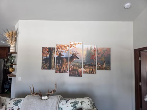 Customer's 'Deer in the Woods' five-panel canvas art installed on a light gray wall in a living room.
