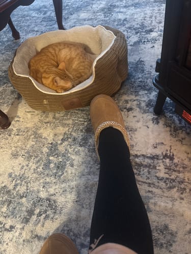 Reviewer wearing black Performance Eucalyptus Compression Socks and slippers while relaxing indoors.