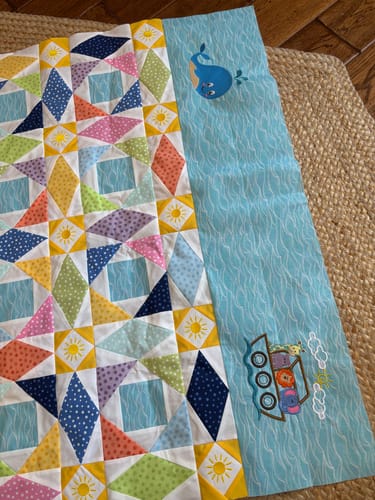 Reviewer's baby quilt in progress, using the light blue Sea Waves Fabric as an embroidered side panel.