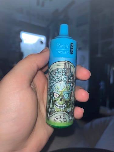 Customer holding a blue RAndM Tornado 9000 vape with a green alien skull graphic.
