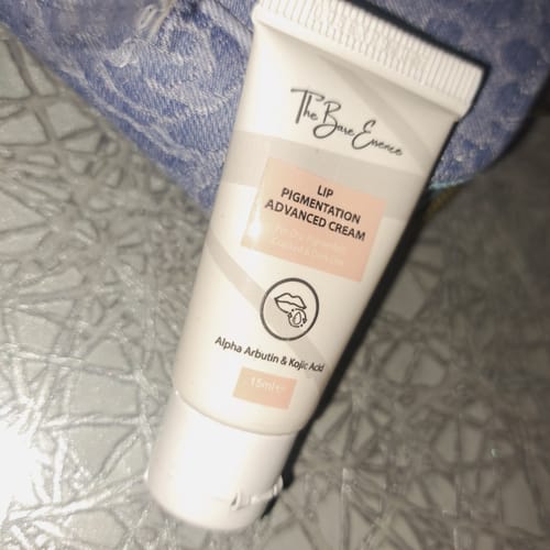 Customer's white tube of Advance Lip Pigmentation Cream resting on a textured surface.