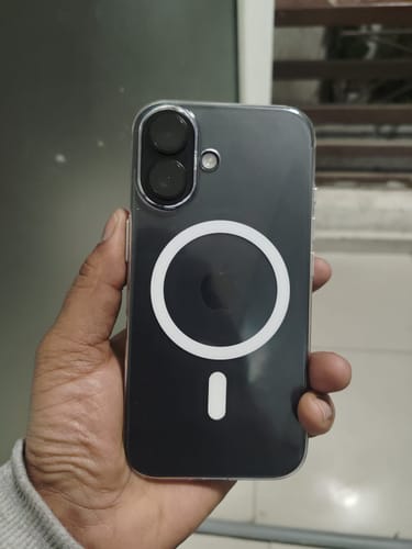 Reviewer holding a dark phone in the transparent Anti Yellow Magsafe case, showing the white magnetic ring on the back.