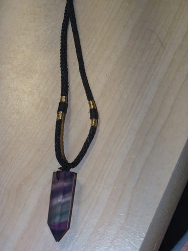 Customer's Natural Fluorite Necklace featuring the banded purple crystal and black cord with gold details.