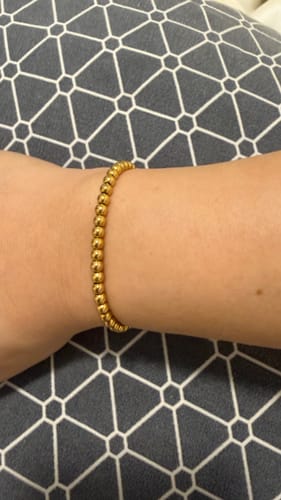 Reviewer wearing the gold Caicos Beaded Bracelet, showing its snug fit on their wrist.