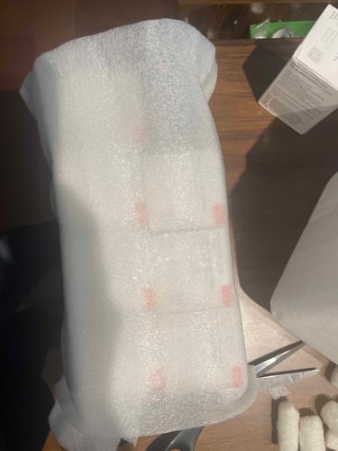 Reseñador muestra el medicamento Higlobin dentro de su embalaje protector de espuma.